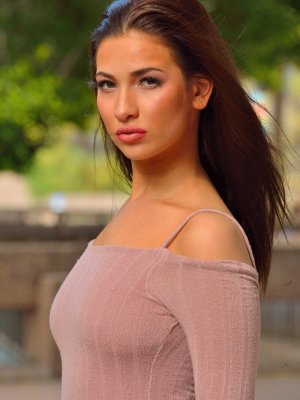 Красивая брюнетка с анальной пробкой позирует голой на улице 